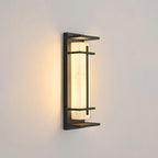 This Clérachic wall light glows softly on a warm beige wall, the dark frame and the pale shade seen at a slight angle.
