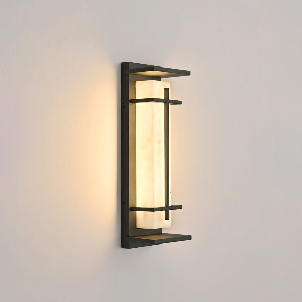 This Clérachic wall light glows softly on a warm beige wall, the dark frame and the pale shade seen at a slight angle.