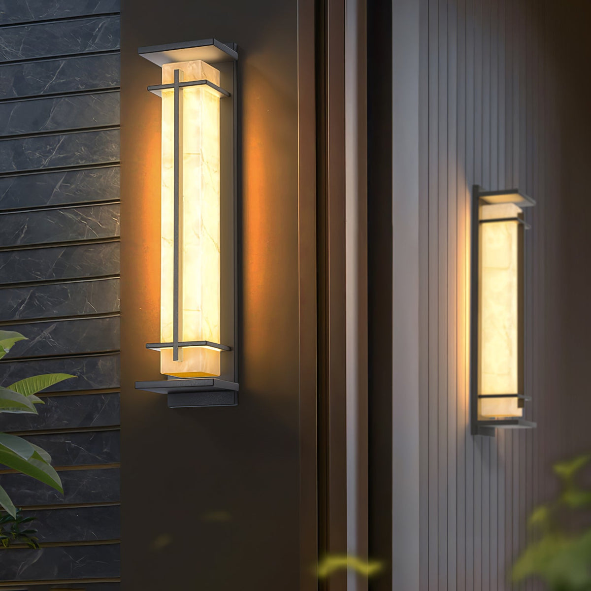 Two lit Clérachic wall lights on dark panelled walls, the nearer one close up with its veined shade glowing amber.