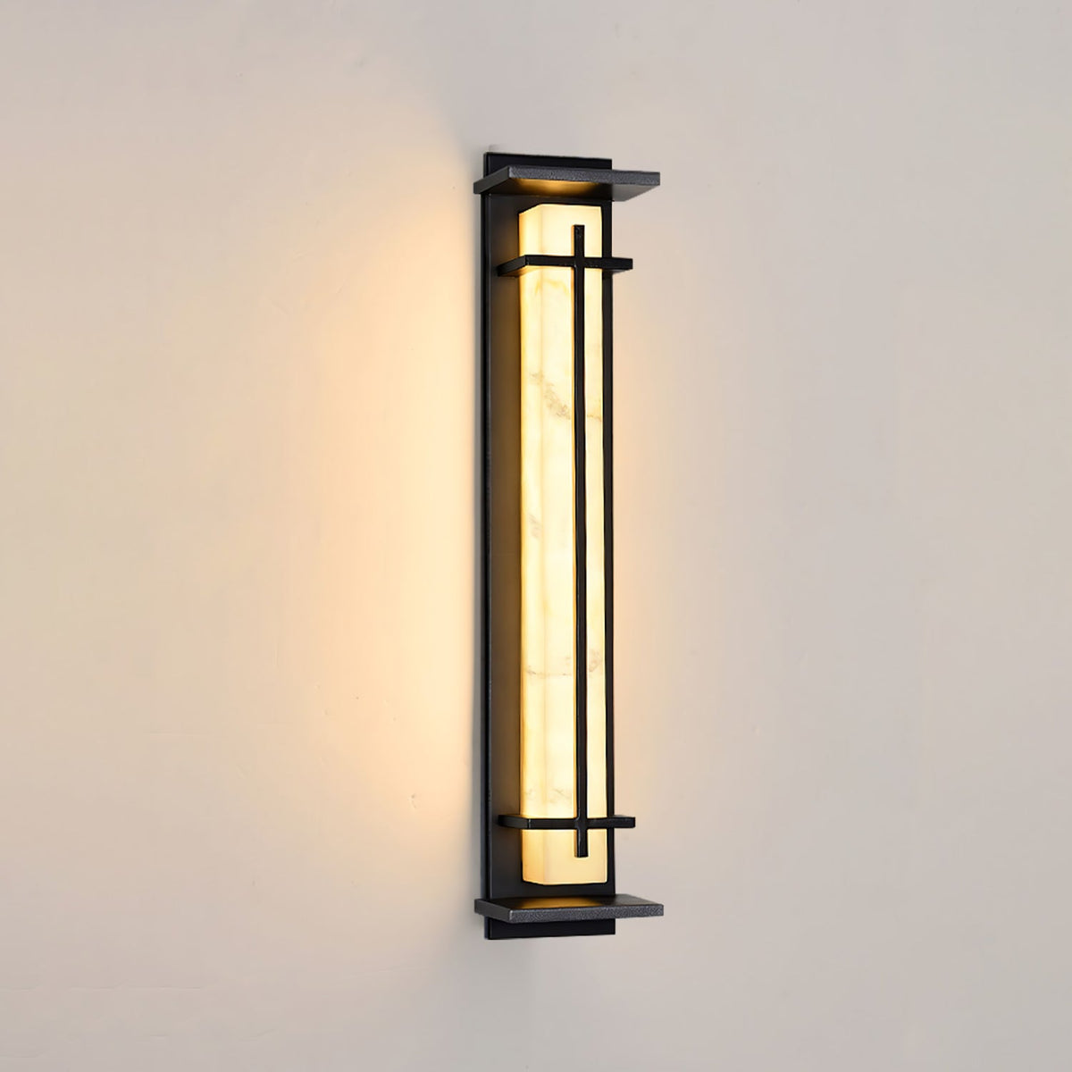 Dark-framed Clérachic wall light lit warm on a cream wall, its pale shade bright with soft shadowing at the top.