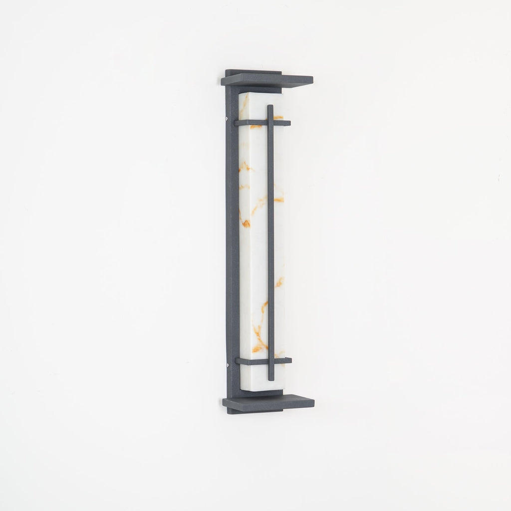 Close view of the unlit wall light, golden marks in its white shade and a grey metal frame, on a white wall; from Clérachic.