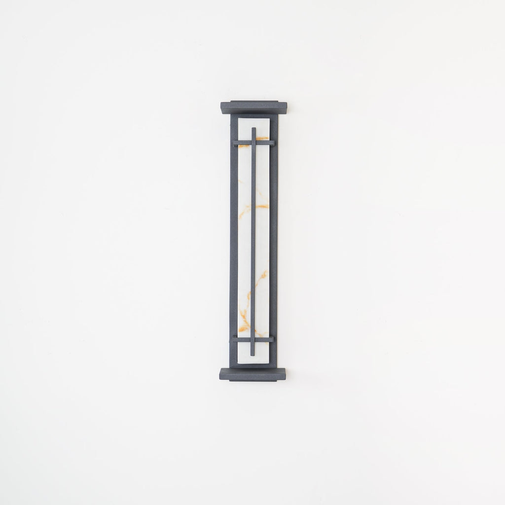 Shorter Clérachic wall light on a white wall, unlit, its pale shade with orange veining behind a slim grey frame.