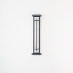 Shorter Clérachic wall light on a white wall, unlit, its pale shade with orange veining behind a slim grey frame.