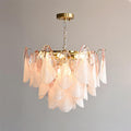 The Clérachic fixture in blush pink glass petals hangs from a brass canopy on a short chain, lit.