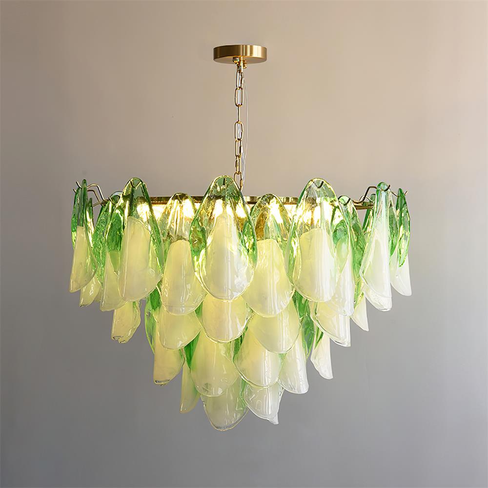 The Clérachic chandelier in sage green glass petals, brass canopy and chain shown against a plain wall.