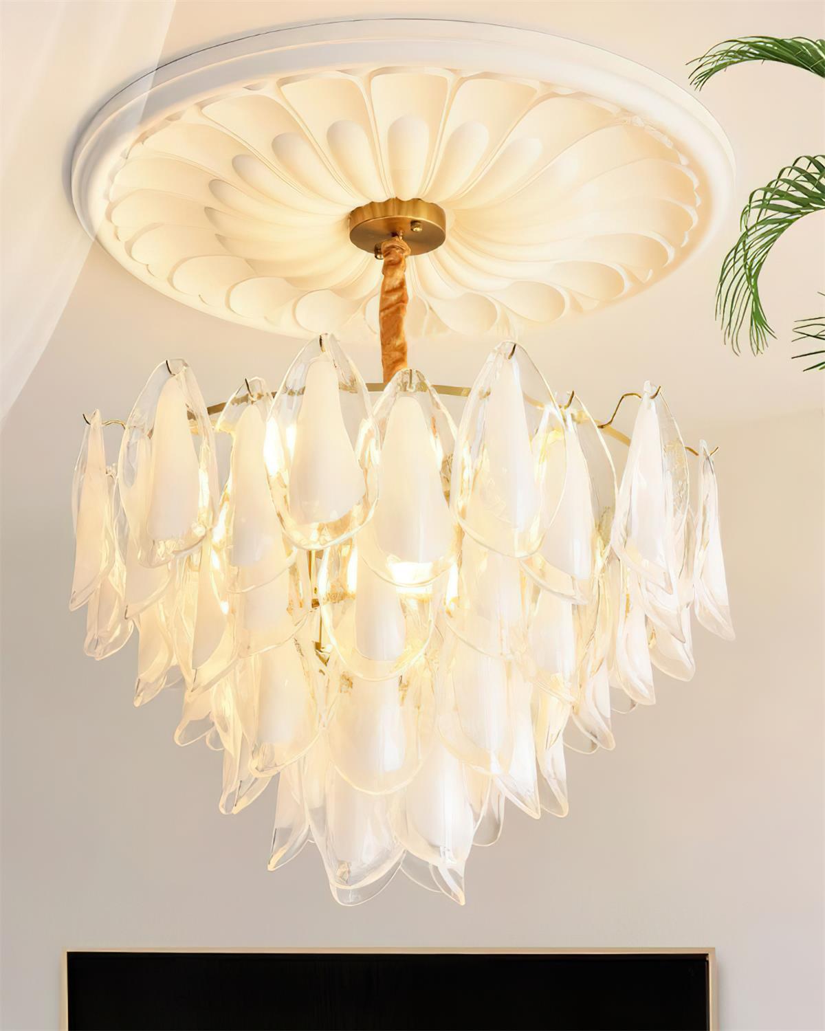 Clérachic chandelier in clear glass petals, no colour tint, hung from a twisted rod near a houseplant.