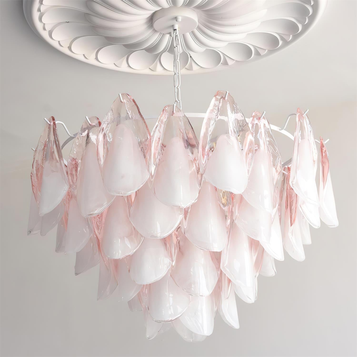 The Clérachic chandelier in blush pink glass petals lit beneath a white ceiling medallion.
