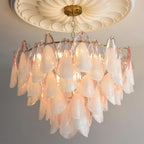 Clérachic close lifestyle view of blush pink glass petals lit warmly under a ceiling medallion.