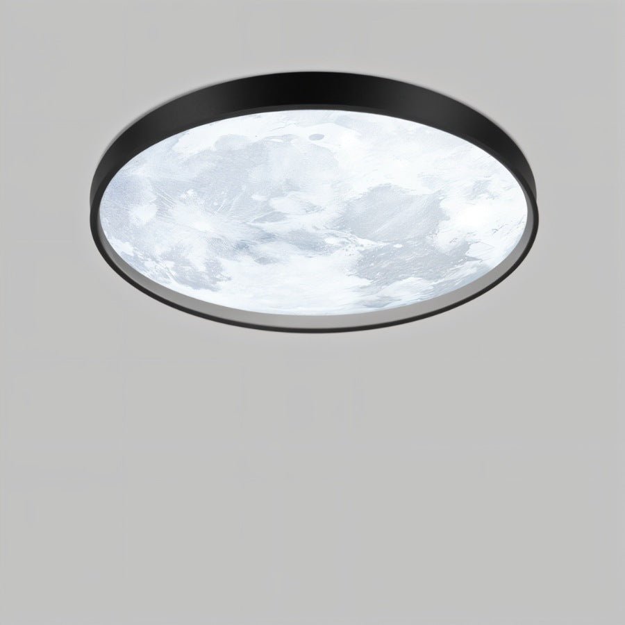 Clérachic slim black-framed ceiling light with a cool-white lunar surface pattern, seen from below on a plain grey ground.