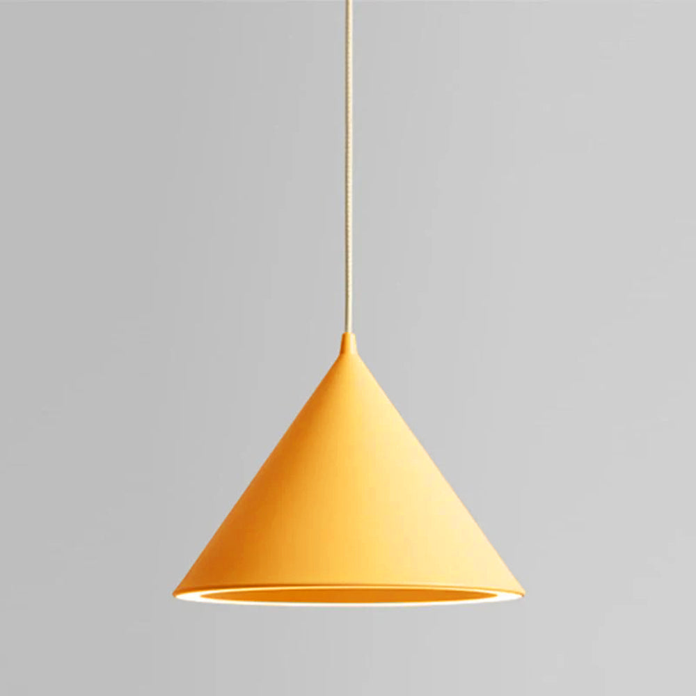 The Clérachic Funnel Pendant Light in yellow on a matching cord, its lit rim sending light straight down onto the surface below.