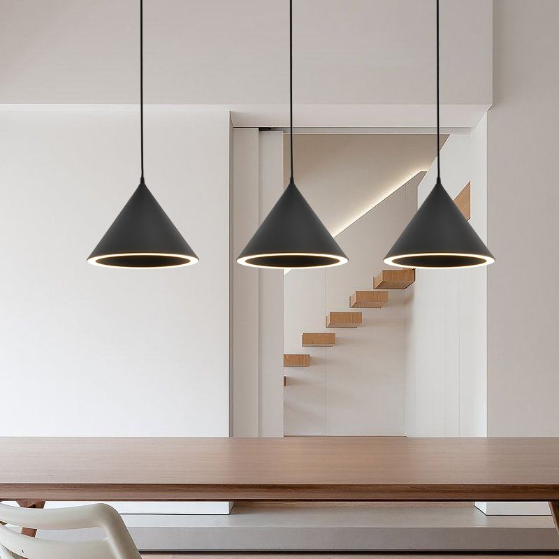 Three black Clérachic Funnel Pendant Lights hung in a row above a walnut dining table in a bright white open-plan hallway.