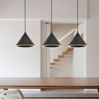 Three black Clérachic Funnel Pendant Lights hung in a row above a walnut dining table in a bright white open-plan hallway.