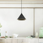 A black Clérachic Funnel Pendant Light over a pale oak sideboard, its lit rim picking out the objects arranged below.