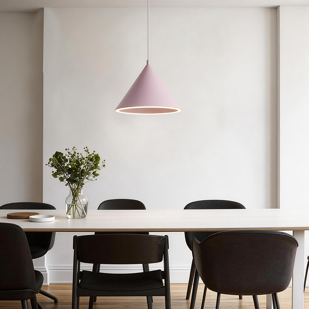 A single pink Clérachic Funnel Pendant Light centred above a pale dining table, its lit ring casting an even glow across the top.