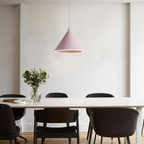 A single pink Clérachic Funnel Pendant Light centred above a pale dining table, its lit ring casting an even glow across the top.