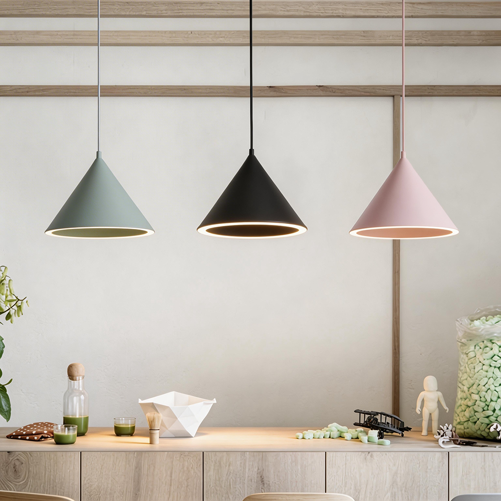 Gray, black and pink Clérachic Funnel Pendant Lights above a kitchen counter, each lit rim laying a warm patch on the wood.