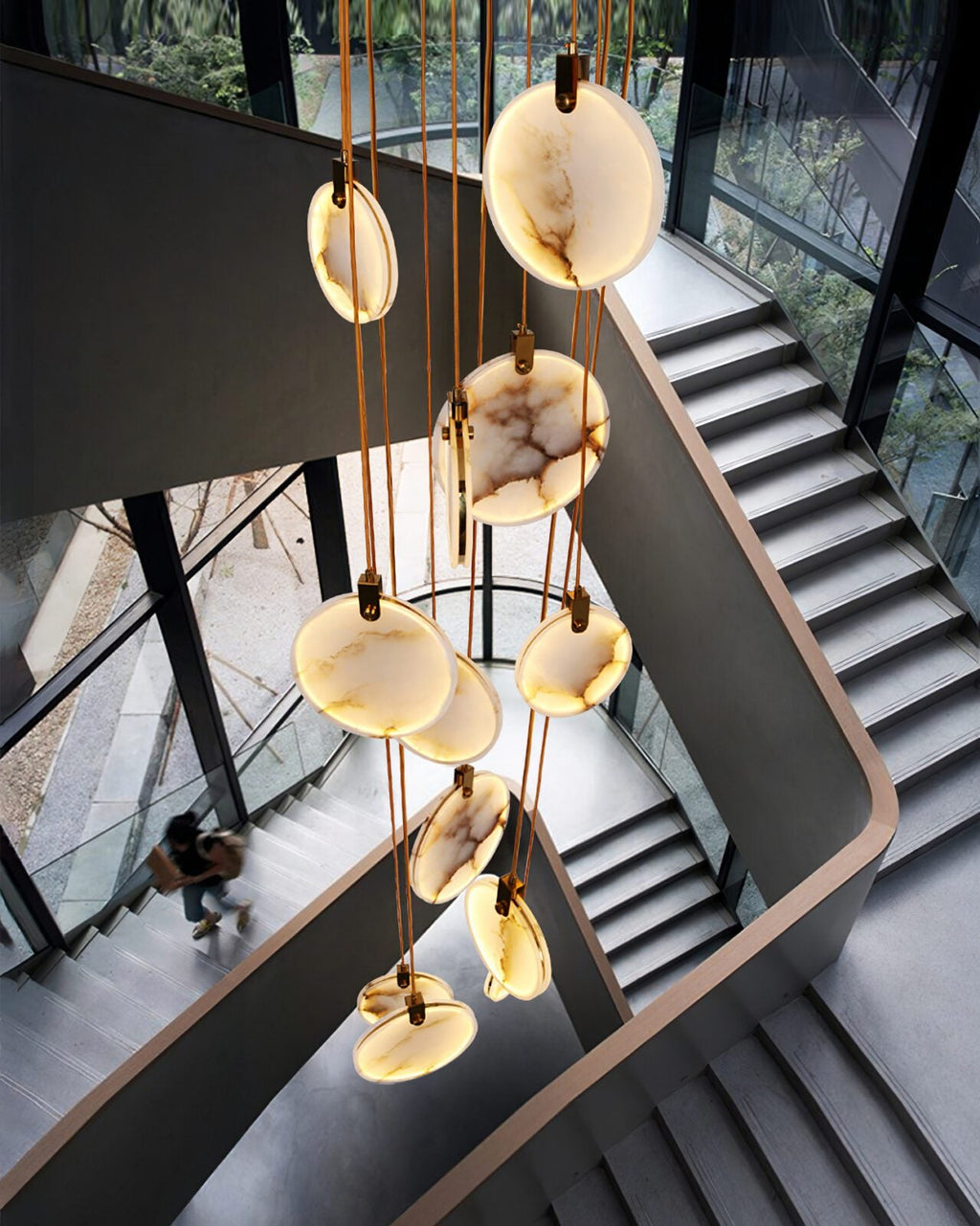 Looking down a dark steel staircase from beside a Clérachic alabaster disc cluster, with a person on the stairs far below.