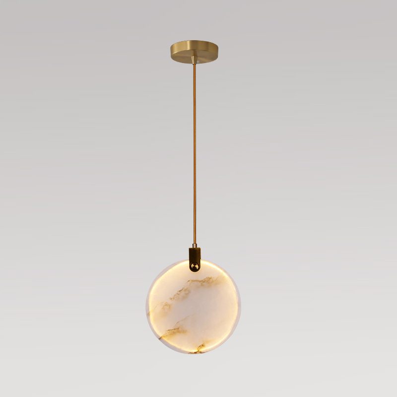 A single Clérachic alabaster disc pendant on a short brass rod and a small gold ceiling plate, on a grey backdrop.