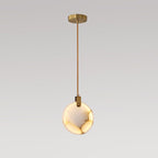 Clérachic alabaster disc pendant on a long brass rod with a gold ceiling plate, lit warm and shown on a grey backdrop.