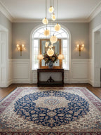 Alabaster disc pendants of this Clérachic cluster hang over a hallway with an arched window, a console table and a blue patterned rug.