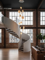Alabaster disc pendants from Clérachic hang in a brick loft with high steel windows and a white spiral staircase.