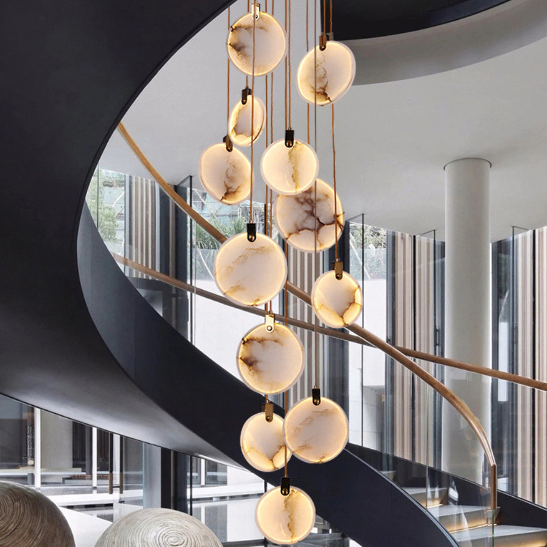 Close view of veined alabaster discs from Clérachic hanging in a black spiral staircase with a timber handrail.