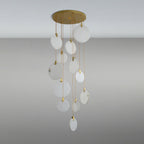 Unlit Clérachic alabaster disc pendants of different sizes hang from a round gold canopy, appearing pale and milky on a grey backdrop.