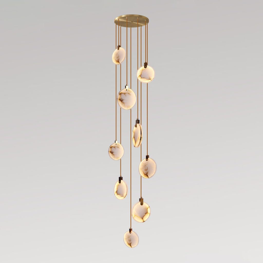 A Clérachic cluster of alabaster discs on tan cords in a loose column from a gold canopy, lit warm on a grey gradient backdrop.