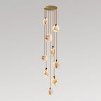 Clérachic alabaster disc pendants on tan cords of differing lengths from a gold canopy, forming a tall narrow cluster on grey.