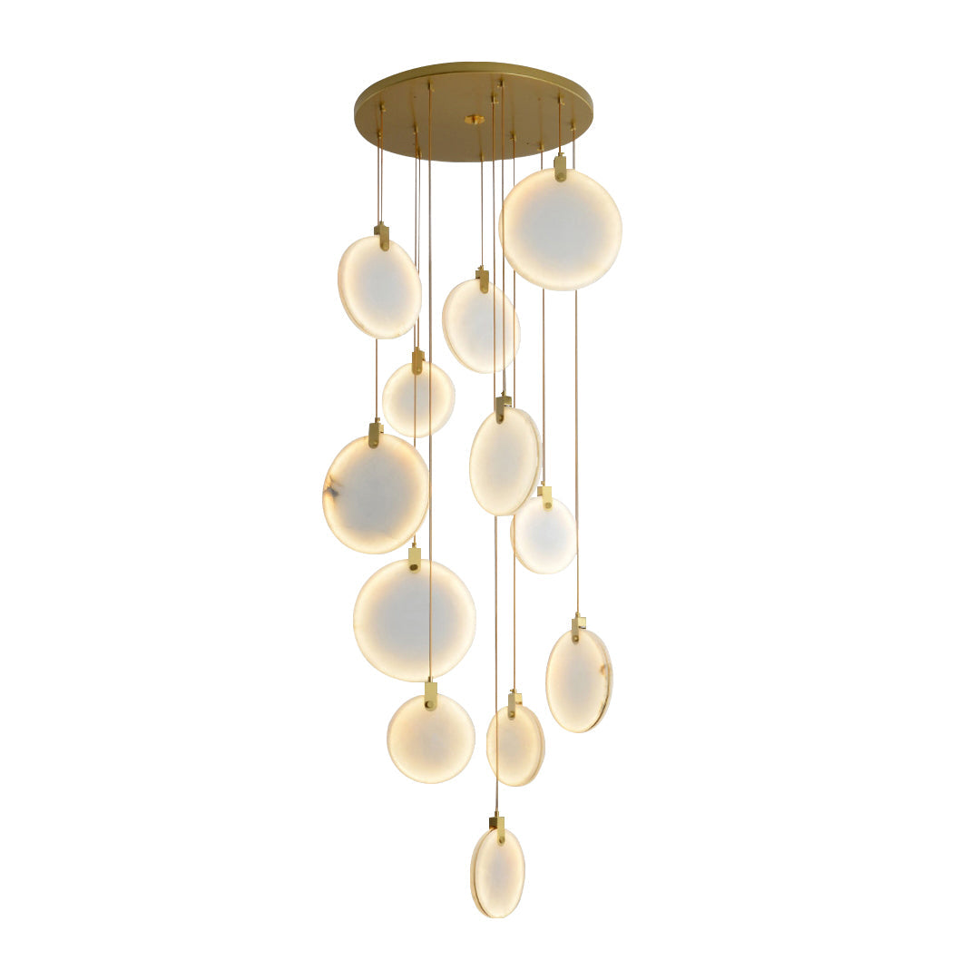 Unlit Clérachic alabaster disc pendants of mixed sizes hang from a round gold canopy, appearing milky white on a white backdrop.