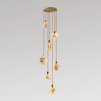 Seven alabaster discs of this Clérachic pendant hang at staggered lengths from a gold canopy, glowing against a pale backdrop.