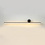 Long horizontal black tube of this Clérachic wall light with a small black disc, lit warmly on a pale wall.