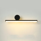Close view of a horizontal black tube and large black disc on this Clérachic wall light, with a warm glow below on a pale wall.