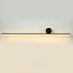 Long horizontal black tube of this Clérachic wall light with a small disc at the right, glowing warmly on a pale wall.
