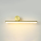 Horizontal gold tube of this Clérachic wall light with a large round gold disc above it, glowing on a pale wall.