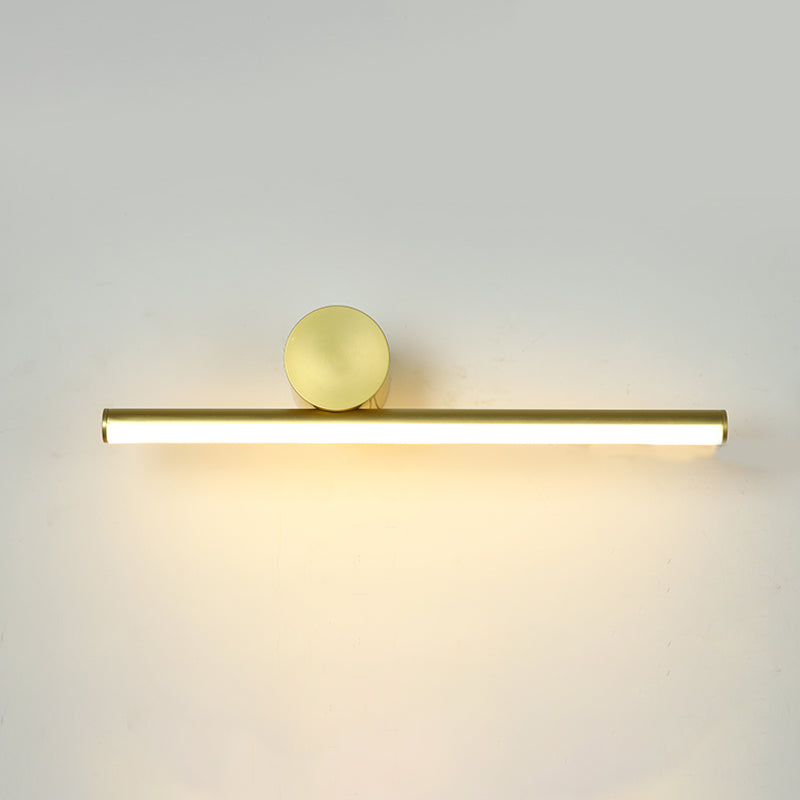Horizontal gold tube of this Clérachic wall light with a large round gold disc above it, glowing on a pale wall.