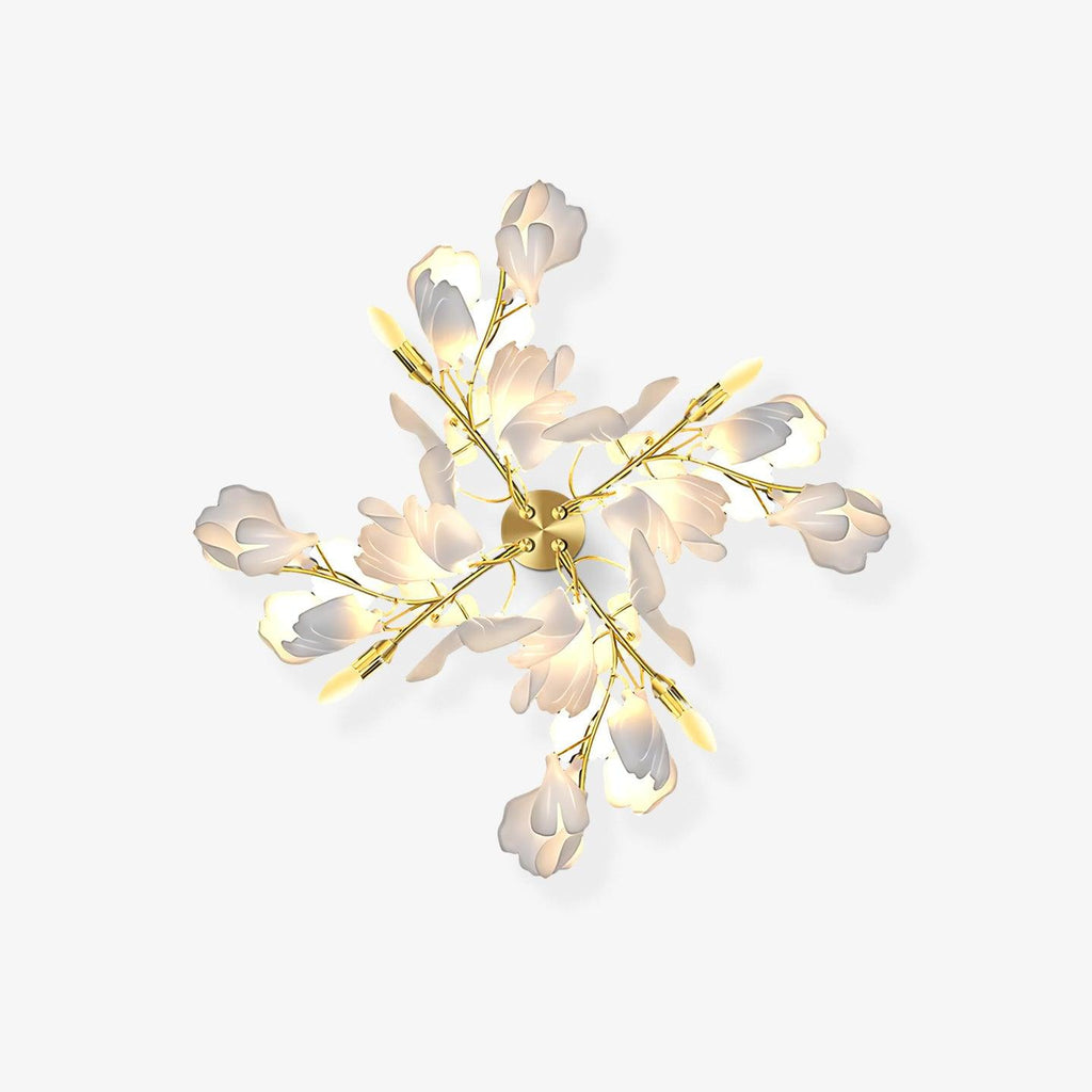 Clérachic gingko wall light on a pale wall, gold branches and white ceramic leaves opened like a bloom.