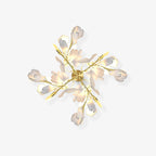 Clérachic gingko wall light on a pale wall, gold branches and white ceramic leaves opened like a bloom.