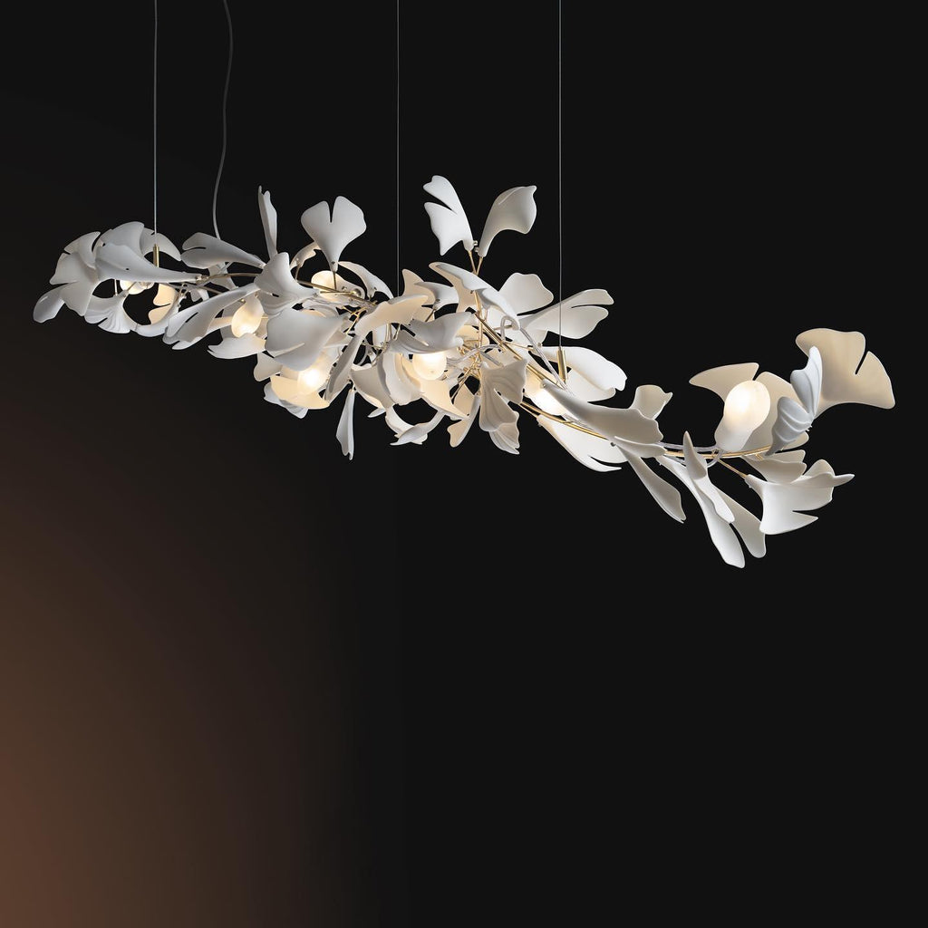 The Clérachic gingko chandelier lit against a black background, every ceramic leaf glowing.