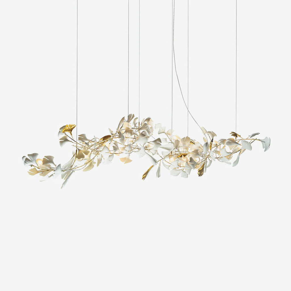 Clérachic gingko linear chandelier on white, a long horizontal spray of ceramic leaves on gold stems.