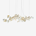 Clérachic gingko linear chandelier on white, a long horizontal spray of ceramic leaves on gold stems.