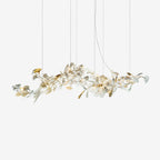 Clérachic gingko linear chandelier on white, a long horizontal spray of ceramic leaves on gold stems.