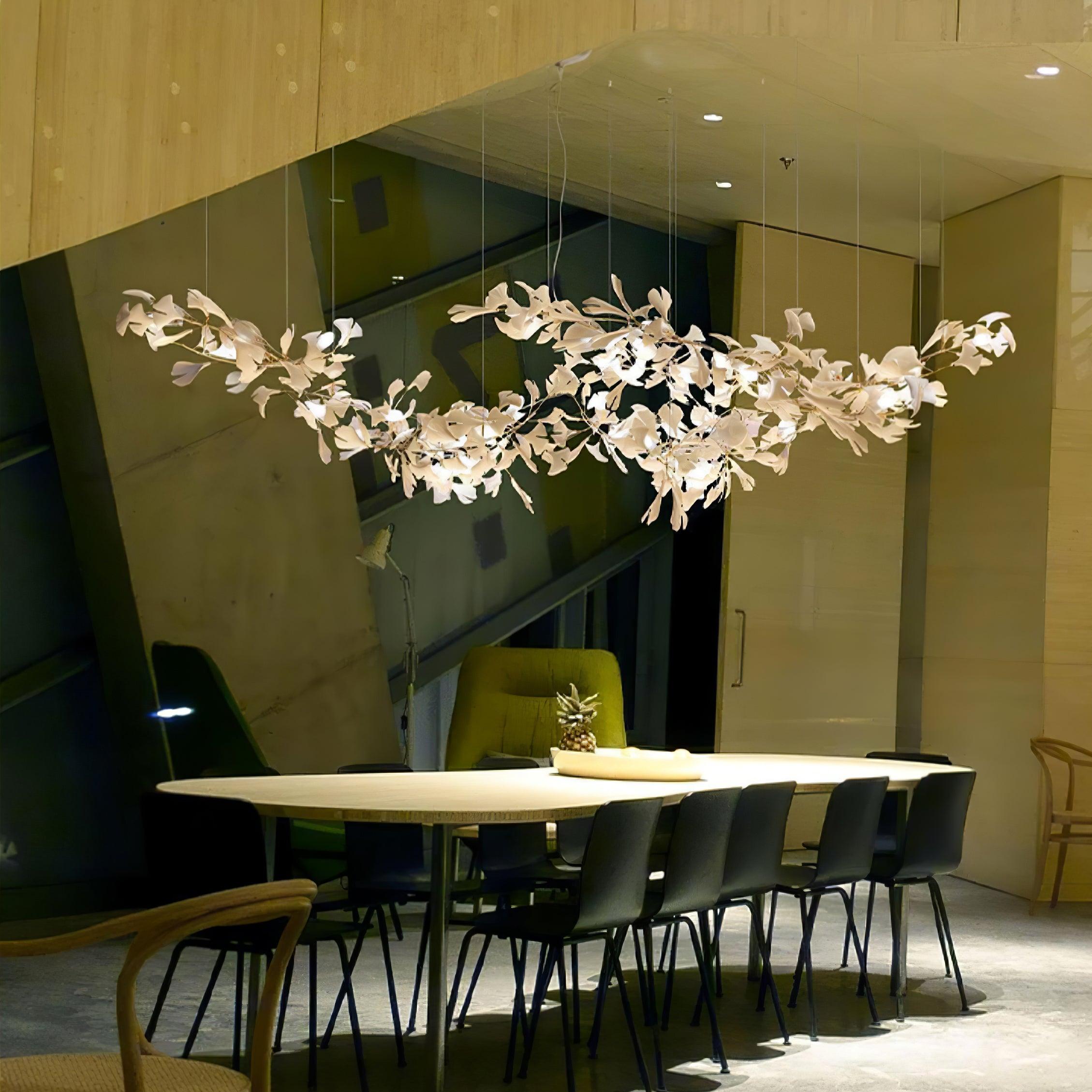 Clérachic gingko chandelier lit above a long meeting table in a timber-lined room.