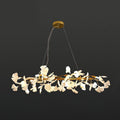 Clérachic gingko ring chandelier lit against charcoal, white leaves circling a gold frame.