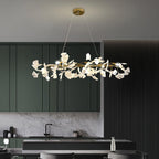 The Clérachic gingko ring chandelier lit above a kitchen island with green cabinetry.
