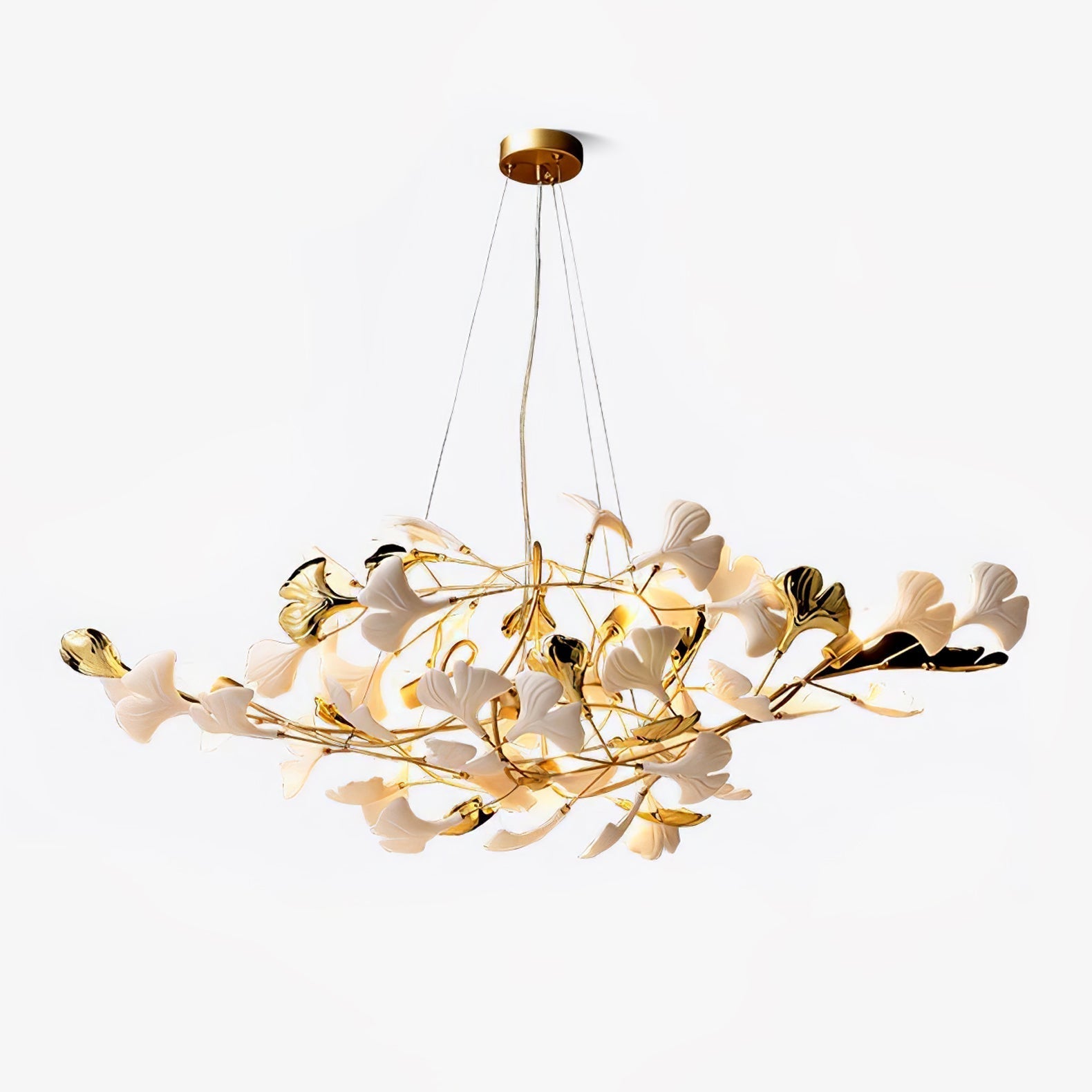 Clérachic gingko chandelier on white, ceramic leaves scattered along gold branches beneath a round canopy.
