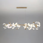 The linear Clérachic gingko chandelier on grey, hung from a slim brass ceiling bar.