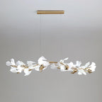 Clérachic linear gingko chandelier seen wider, its leaves spread along the full brass bar.