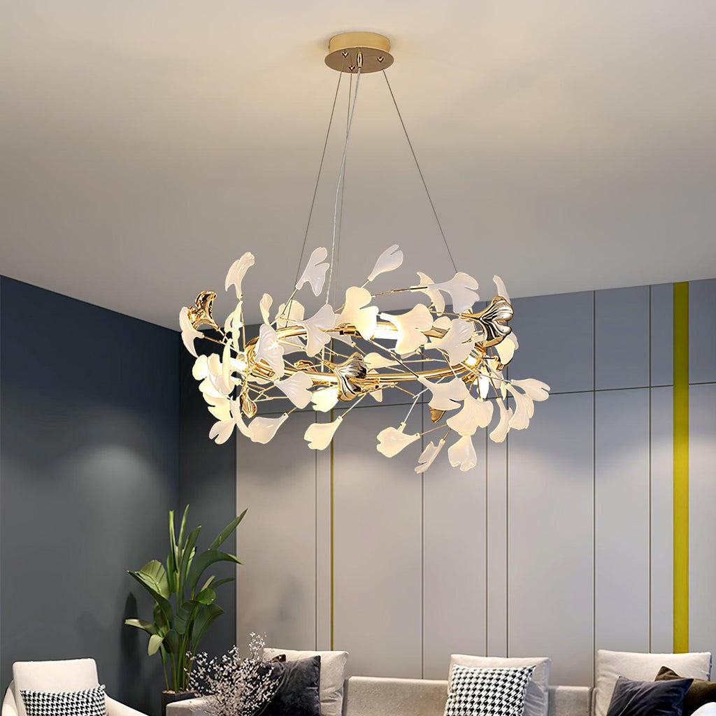 Clérachic gingko chandelier lit in a navy-panelled living room above a pale sofa.