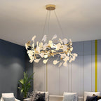 Clérachic gingko chandelier lit in a navy-panelled living room above a pale sofa.
